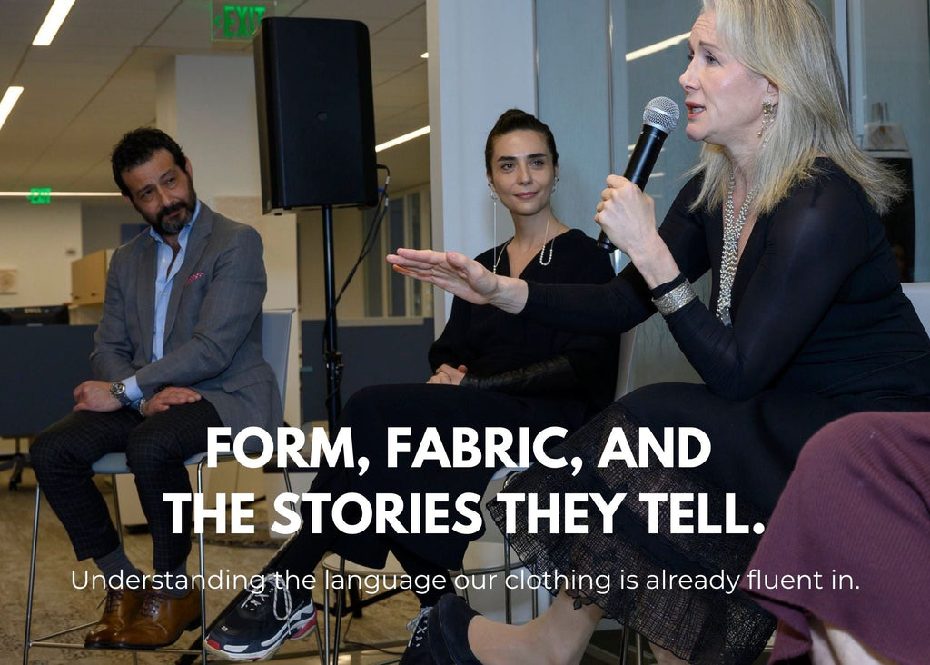 Pauline Brown speaks into a handheld microphone during a panel discussion, seated beside Bela Shehu, who listens attentively. A third panelist sits to the left. The group is in a modern office setting with fluorescent lighting and neutral interiors.