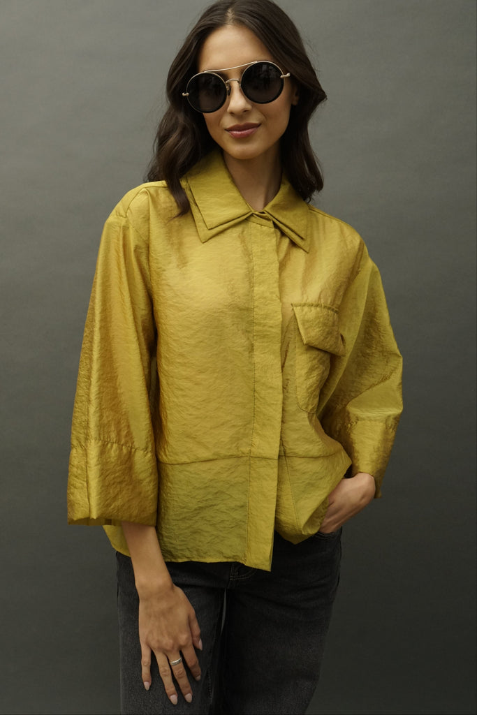 Close-up of crisp silk organza fabric in mustard tone highlighting the double collar and oversized sleeves