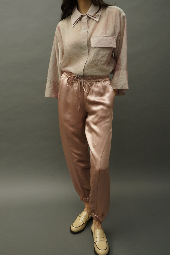 Front view of Cass rose-gold satin joggers with tapered leg and elastic cuffs