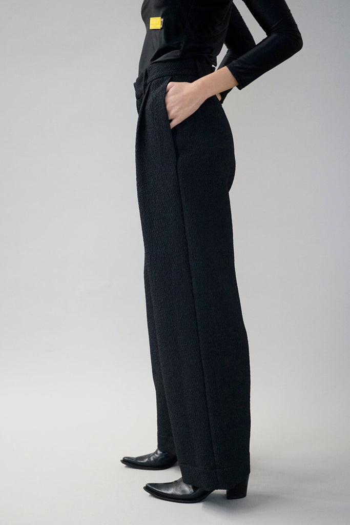 Chic black wide-leg pants for women styled with a fitted long-sleeve top, perfect for a modern and elegant look.