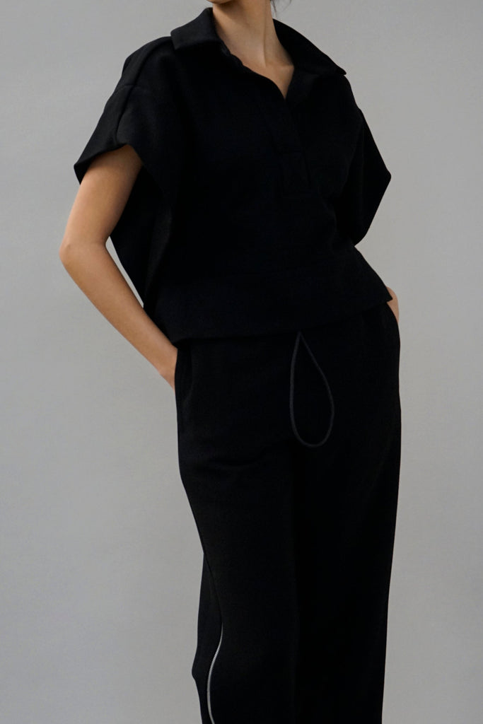 Chic black ensemble for women with a relaxed short-sleeve top and drawstring pants, ideal for contemporary fashion trends.