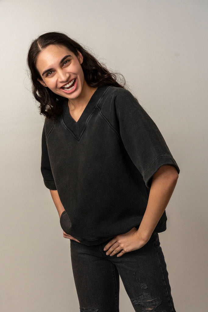 Smiling model wearing black V-neck short sleeve sweatshirt from Unbranded