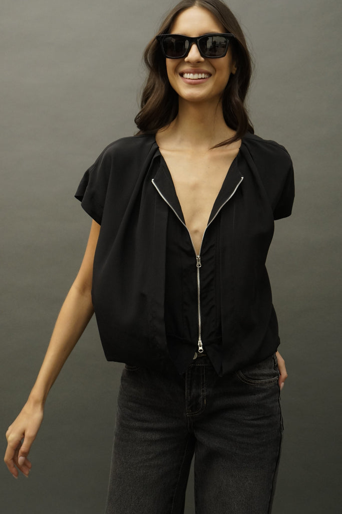 Front view of Zee sleeveless black silk blouse with pleated drape neck and two sided silver zipper