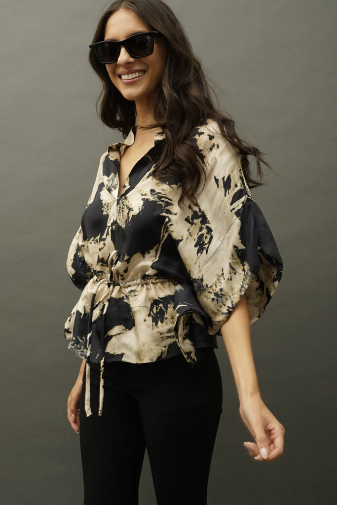Side angle highlighting dual-tone floral print on flowing silk top