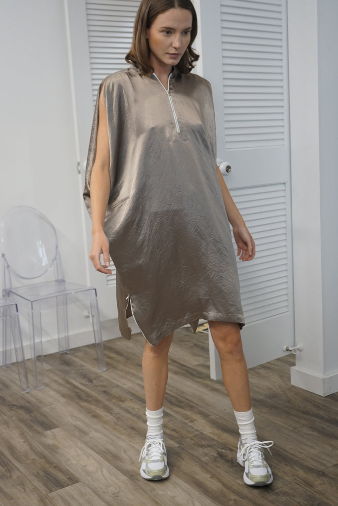 A model wearing the Nell Oversized Tunic Dress, showing a front view to highlight the loose fit and the front zipper detail.