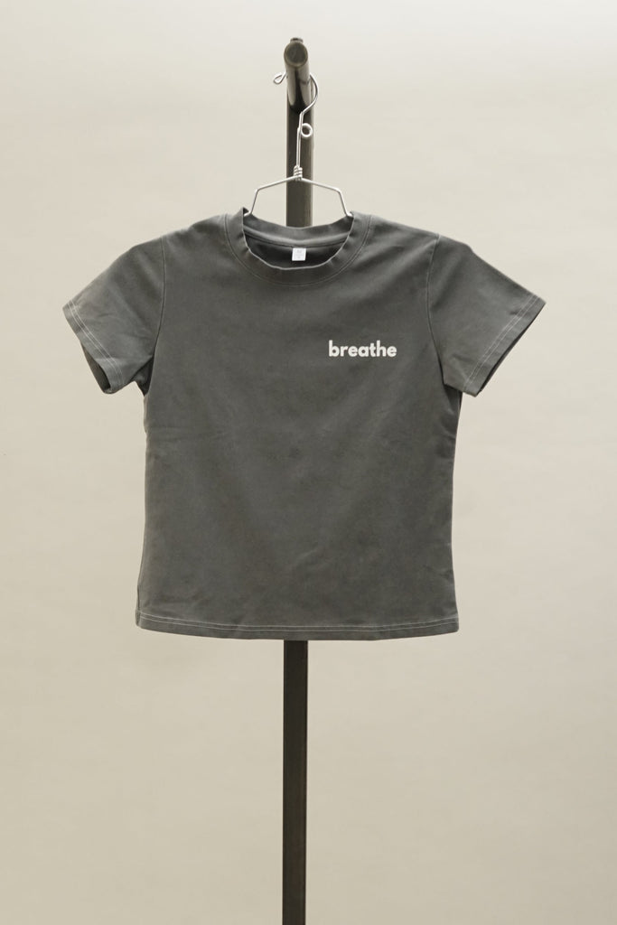 Charcoal form-fitting short sleeve crew neck t-shirt with the word ‘breathe’ printed on the front, shown against a simple neutral background.