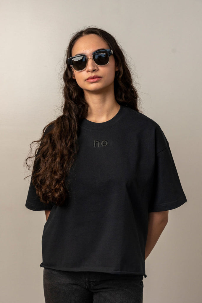 Woman wearing black Unbranded oversized t-shirt with “no” embroidery and black sunglasses