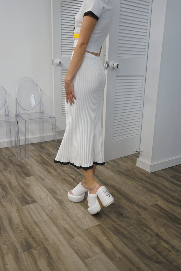 A video thumbnail showing a model moving or walking in the Coco Skirt to demonstrate the fabric's flow and drape.