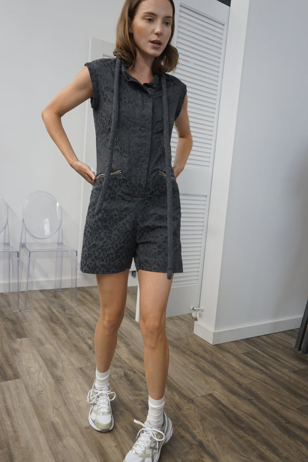 A video thumbnail showing a model moving or walking in the romper to demonstrate the fabric's flow and the fit.