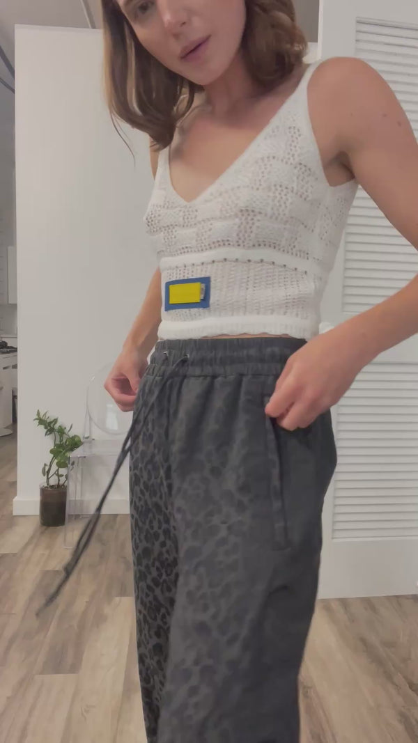 A thumbnail of a video of a model describing the fit of the gray animal print jogger pants by NINObrand